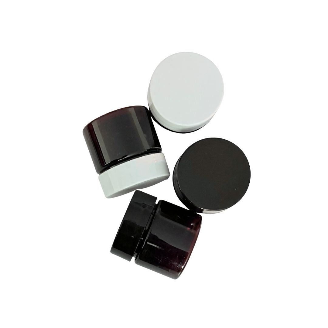 Black and white cosmetic jars on a white background